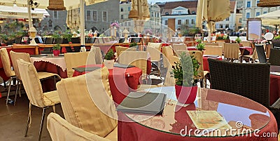 Street Cafe Tables chairs with cup of coffee Flowers City lifestyle Summer Day In Old Town Of Tallinn travel and tourism To Est Stock Photo