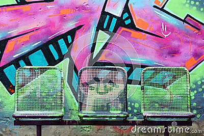Street chairs in front of graffiti wall Editorial Stock Photo