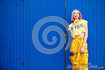 Street Fashion Woman with dying Pink Hair color wear yellow chic dress Stock Photo