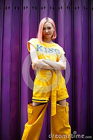 Street Fashion Woman with dying Pink Hair color wear yellow chic dress Stock Photo