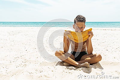 Street food concept. Young handsome hipster guy holding, eating meat pasty on the beach. Caucasian, Cheburek Stock Photo
