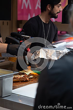 Street food, cooking sandwiches with flame. Old Spitalfields Market. London Editorial Stock Photo