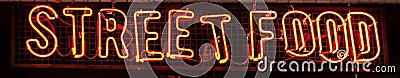 Street Food Neon sign on a Graffiti. Bricks wall Stock Photo