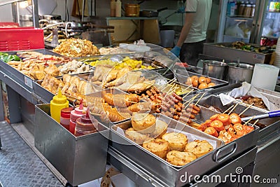 A street food stall in Hong Kong selling different types of deep fries and barbecued food. Demonstrating Asian street food culture Stock Photo