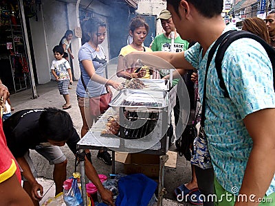 A street food vendor sells barbecue in a food cart along a street in Antipolo City, Philippines Editorial Stock Photo