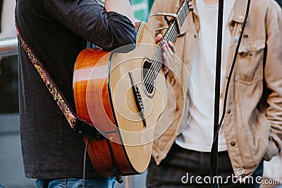 Street guitarist guitar strings strap wood melodies instrument folk Stock Photo