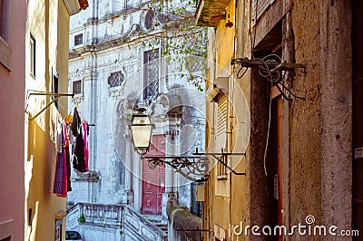 Street lamp and laundry in a picturesque narrow street of Alfama in the old town of Lisbon Portugal Stock Photo