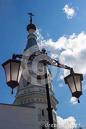 A street lamp and a tent-roofed bell tower of the Russian Orthodox Church in the background Stock Photo