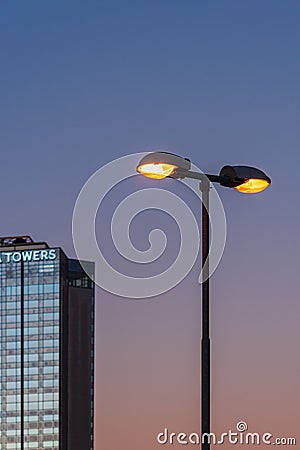 Street light fixture situated next to a large, modern office building Editorial Stock Photo