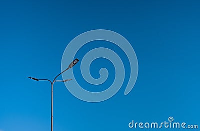 The street light pole with a blue sky background - Automatic street twin lamp against the blue sky with copy space Stock Photo