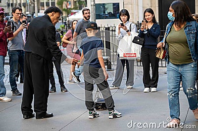 Street magician does magic trick with young man with spectators Editorial Stock Photo