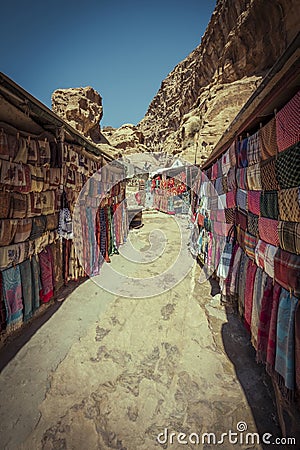 street with market in the ancient city of Petra in Jordan with souvenir products, fabrics and carpets with national Bedouin ornam Stock Photo
