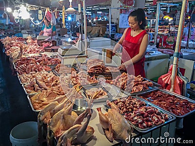 A street meat vendor works in a local market in China Editorial Stock Photo