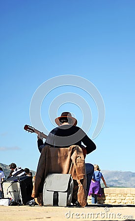 Street musician playing the spanish guitar with a blue sky background, Ronda, Spain Editorial Stock Photo