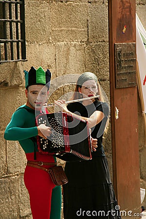 Street musicians in harlequin costumes. Editorial Stock Photo