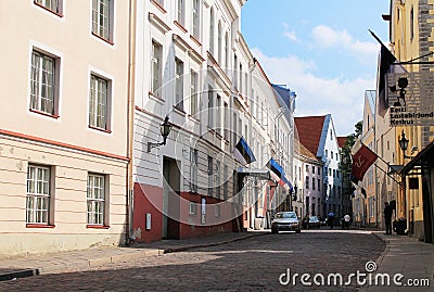 Street of Old Tallinn. Medieval houses, facades. On the houses are Estonian, Russian and Finnish flags Editorial Stock Photo