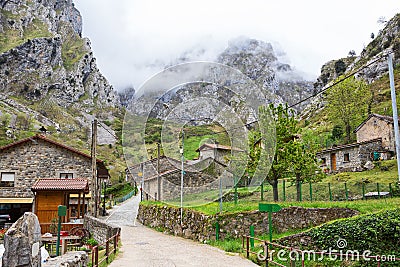 Street with old typical houses in a cloudy spring day, Cain de Valdeon, Picos de Europa, Castile and Leon, Spain. Cain is a villa Stock Photo