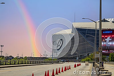 A street with orange cones and cars driving surrounded by Mercedes-Benz Stadium, lush green trees with a gorgeous clear blue sky Editorial Stock Photo