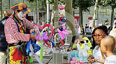 Street Performer Clown entertains kids with Balloon Animals Editorial Stock Photo