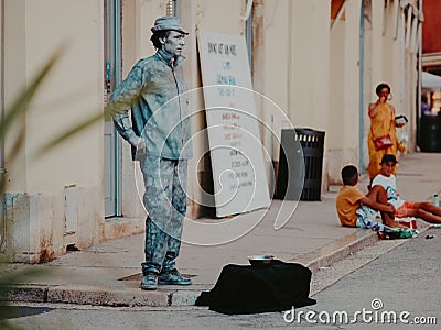 Street performer mime stands in the form of live silver statue sculpture in the center of the old city. Live perfomance for Editorial Stock Photo