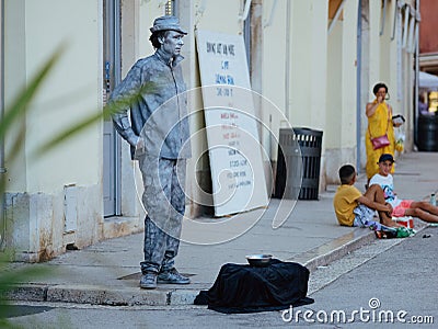 Street performer mime stands in the form of live silver statue sculpture in the center of the old city. Live perfomance for Editorial Stock Photo