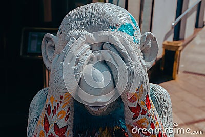 Street photo of a figure of a bright multicolored monkey with closed eyes of unusual color depicts various emotions. Moscow. Editorial Stock Photo