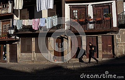 A Street Photographer walks in the Streets of Guimares, chasing light and shadows, Guimares, Portugal. Editorial Stock Photo