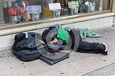 Street Photography: Homeless Sleeping on the Street in front of a Store Window Editorial Stock Photo