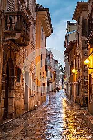 Street in Porec town illuminated by lamps at the evening. Stock Photo