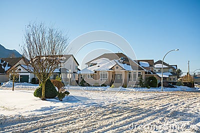 Street of residential houses in snow on winter sunny day Stock Photo