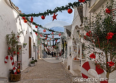 street in the Rione Monti District of Alberobello with Trulli houses and huts and colourful Christmas decorations Editorial Stock Photo