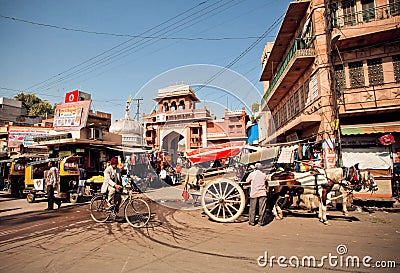 Street with rushing people, cycles and horses Editorial Stock Photo