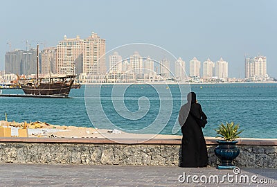 Street scene in Doha, Qatar with lady wearing traditional Qatari black dress and head cover Editorial Stock Photo