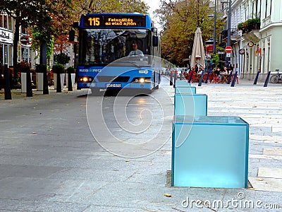 Street scene with electric bus on downtown walking alley with restaurant terraces Editorial Stock Photo