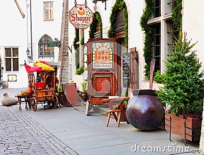 Street scene in old Tallinn, Estonia Christmas tree and old trading cart with a red tent stay near Medieval wall of Editorial Stock Photo