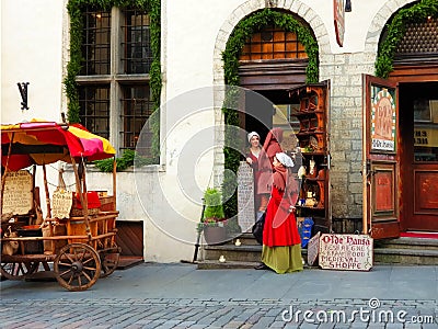 Street scene in old Tallinn, Estonia girl in medieval red dresses selling fried almonds for tourist in an old tradi Editorial Stock Photo