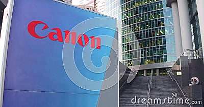 Street signage board with Canon Inc. logo. Modern office center skyscraper and stairs background. Editorial 3D rendering Editorial Stock Photo