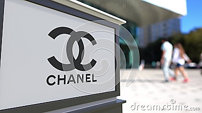 Street signage board with Chanel logo. Blurred office center and walking people background. Editorial 3D rendering Editorial Stock Photo