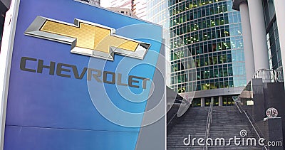 Street signage board with Chevrolet logo. Modern office center skyscraper and stairs background. Editorial 3D rendering Editorial Stock Photo