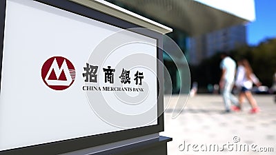 Street signage board with China Merchants Bank logo. Blurred office center and walking people background. Editorial 3D Editorial Stock Photo