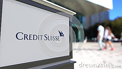 Street signage board with Credit Suisse Group logo. Blurred office center and walking people background. Editorial 3D Editorial Stock Photo