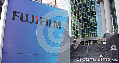 Street signage board with Fujifilm logo. Modern office center skyscraper and stairs background. Editorial 3D rendering Editorial Stock Photo