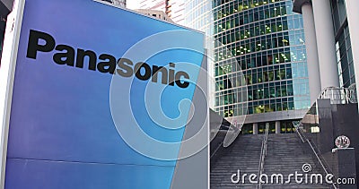 Street signage board with Panasonic Corporation logo. Modern office center skyscraper and stairs background. Editorial Editorial Stock Photo