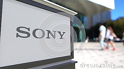 Street signage board with Sony Corporation logo. Blurred office center and walking people background. Editorial 3D Editorial Stock Photo