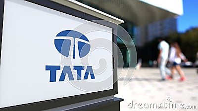 Street signage board with Tata Group logo. Blurred office center and walking people background. Editorial 3D rendering Editorial Stock Photo