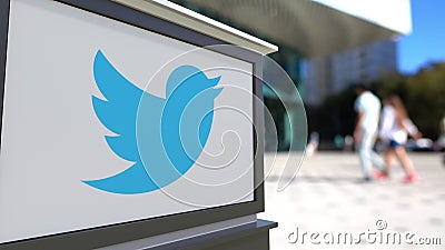 Street signage board with Twitter, Inc. logo. Blurred office center and walking people background. Editorial 3D Editorial Stock Photo