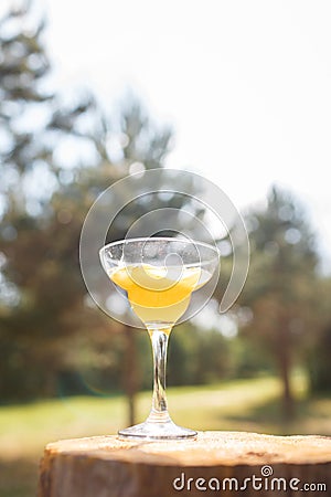 A glass on a high stem with a yellow drink. Stock Photo