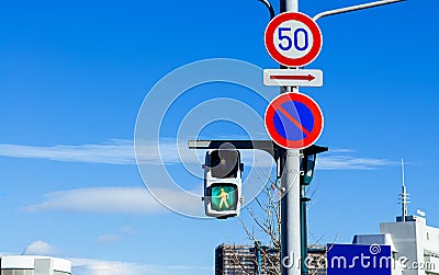 Street traffic light crosswalk sign against blue sky Stock Photo