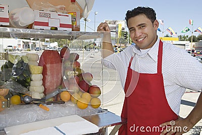 Street Vendor Standing By Stall Stock Photo