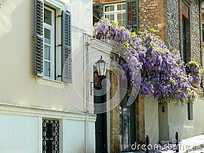 Street view of homes with purple wisteria flowers in Athens Greece Stock Photo